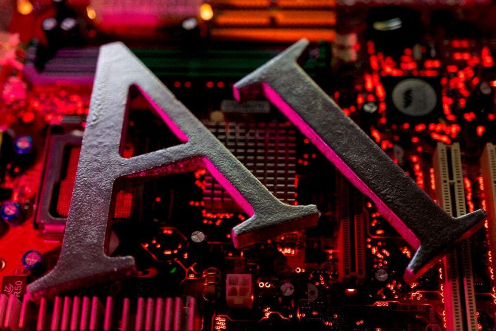 Journalism in the AI era: Illustration of the letters 'AI' against a pink circuit board.