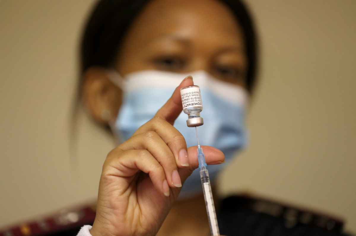 A health worker holds a vial of the Pfizer/BioNTech coronavirus disease (COVID-19) vaccine, at the Munsieville Care for the Aged Centre outside Johannesburg, South Africa May 17, 2021. REUTERS