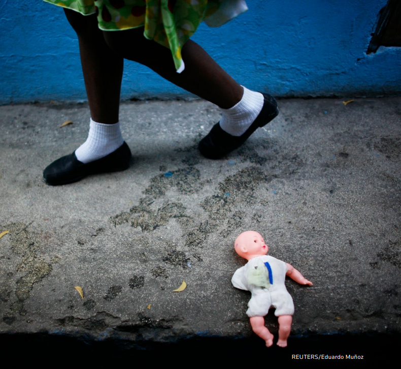 A child walks next a doll before a visit by Ann M. Veneman, UNICEF Executive Director, at the Notre Dame orphanage in Port-au-Prince