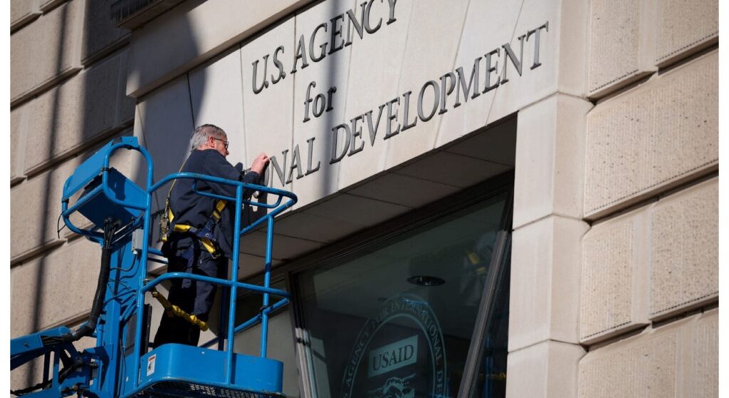 USAID sign being dismantled 