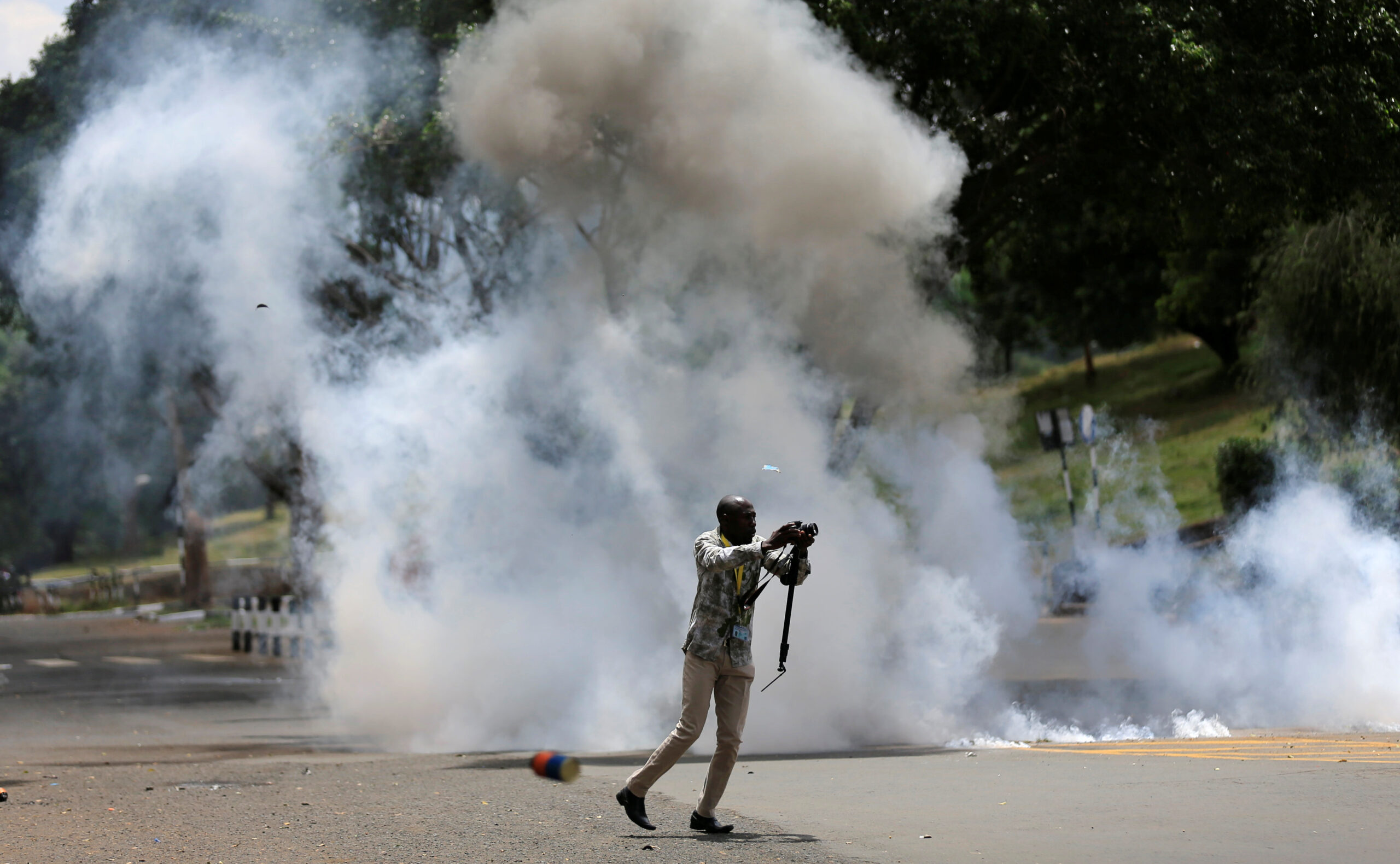 A journalists runs past a cloud of tear gas after riot police dispersed anti-corruption protesters opposing the graft and abuse of funds in public healthcare, during a demonstration in Kenya's capital Nairobi, November 3, 2016.